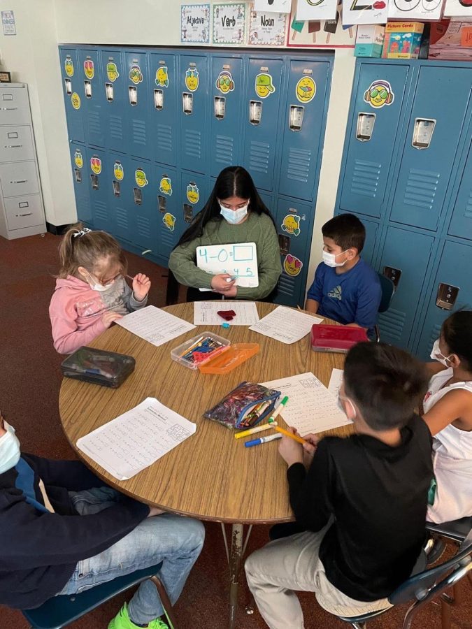 Education+intern+Jocelynne+Gutierrez+Guzman+explains+subtraction+to+a+small+group+of+Parlin+elementary+students.