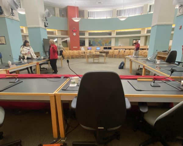 This was the scene in the EHS library last Monday before a tense School Committee meeting leading to a 7-3 vote to place Superintendent Priya Tahiliani on non-disciplinary paid leave.  The unoccupied seat here would later be used by Committee Chair Mike Mangan sat in while leading the meeting.