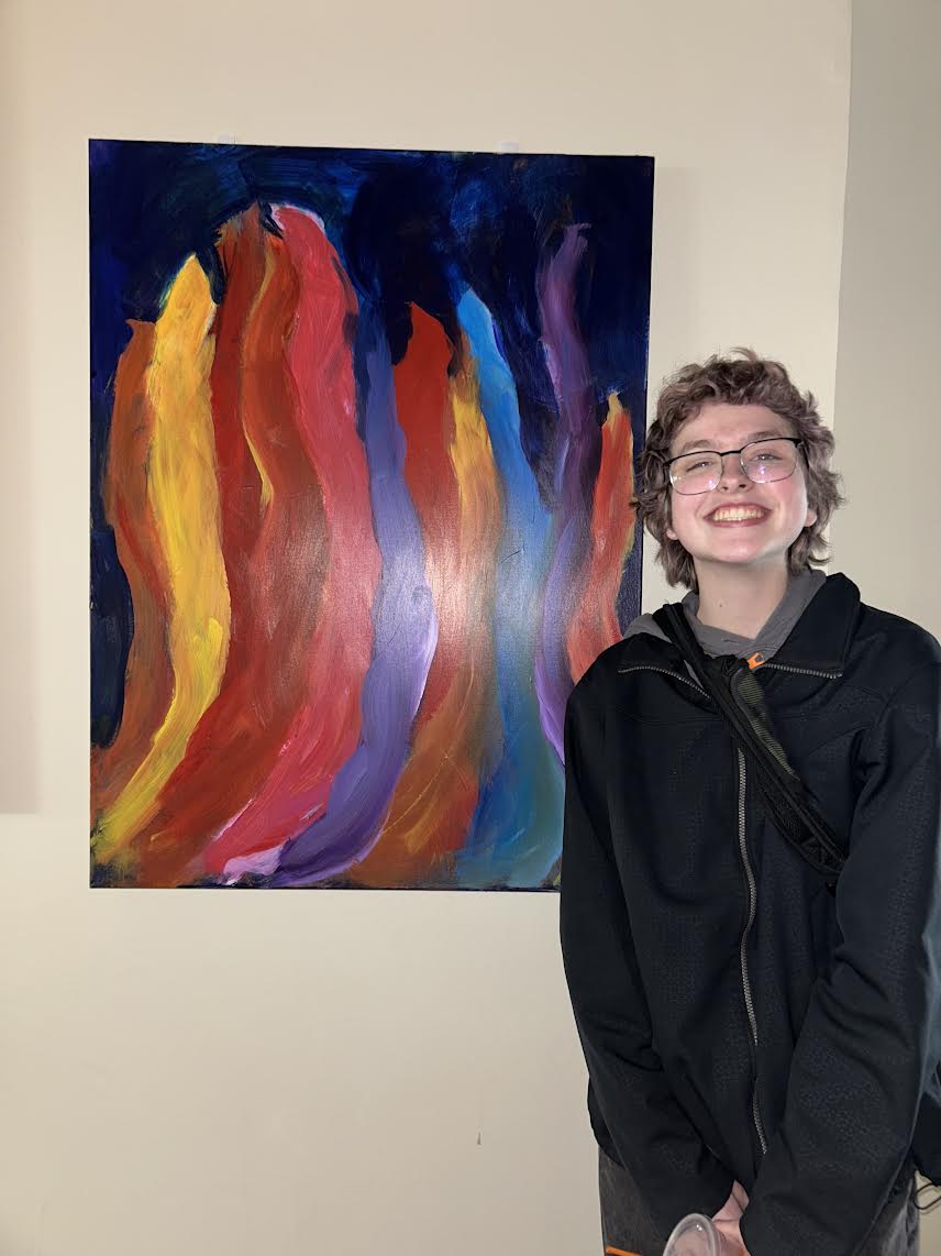 Senior Ace Donnelly posed next to his colorful flame painting he did in his Intermediate Painting class.