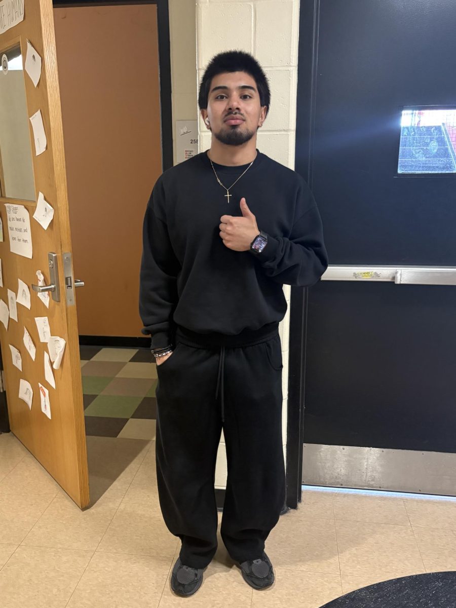 Angel Chinchilla wearing a black sweatshirt from Tilly's, black sweatpants from Woolenmaker, and black shoes from New Balance.