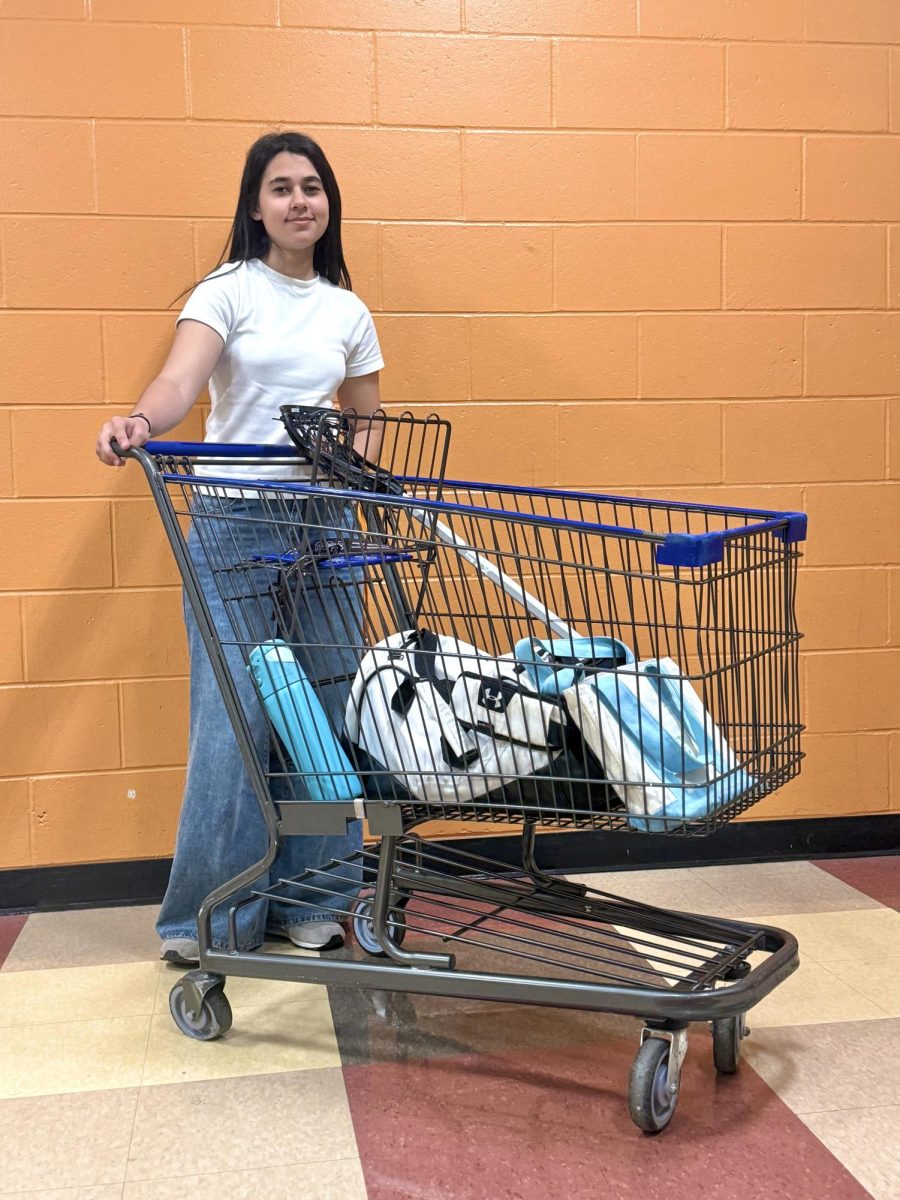 Senior Saline Duck ready to roll with a shopping cart for Spring Spirit Week’s Anything But A Backpack Day
